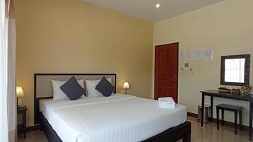 A hotel room with a large bed, bedside tables, a desk, and a chair.