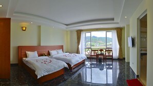 A hotel room with two beds, a balcony, and a view of the landscape. - White Lotus (Lao Cai)