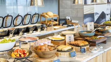 A buffet with various dishes, including fruits, eggs, and bread.
