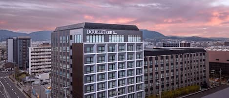 Un hotel moderno con fachada de diseño geométrico, varios pisos y un letrero llamativo.