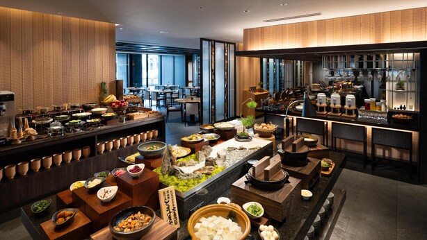 A buffet with various dishes and a bar area with glasses and bottles.