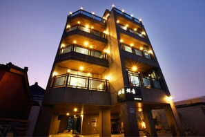 Vista frontal de la propiedad por la tarde o noche