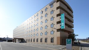 A multi-story hotel with a modern design, featuring a prominent sign for the Tsuruoka Inn. - Hotel Inn Tsuruoka (Tsuruoka)