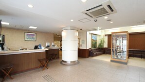 A reception area with a counter, seating, and a glass display case. - Hotel Inn Tsuruoka (Tsuruoka)