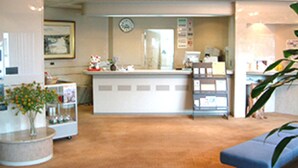 A reception area with a counter, a clock, and a plant. - Attamari Land Fukabori (Oishida)