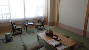 A traditional Japanese room with tatami flooring, a low wooden table, two chairs, a small table with a bowl, and a window with blinds. - Attamari Land Fukabori (Oishida)