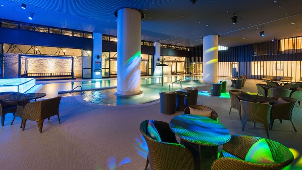 A spacious indoor area with a pool, lounge chairs, and tables. - Asia Pacific Hotel Beitou (Taipei)