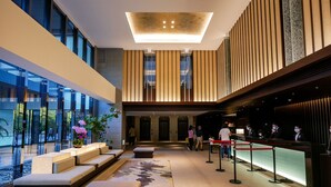 A modern lobby with a seating area, a reception desk, and a large glass wall offering views of the outdoors. - Asia Pacific Hotel Beitou (Taipei)