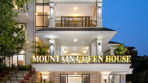 Un hôtel à plusieurs étages, doté d’une entrée imposante et d’un balcon.