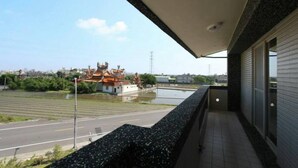Un balcón con vista a un templo y una carretera.