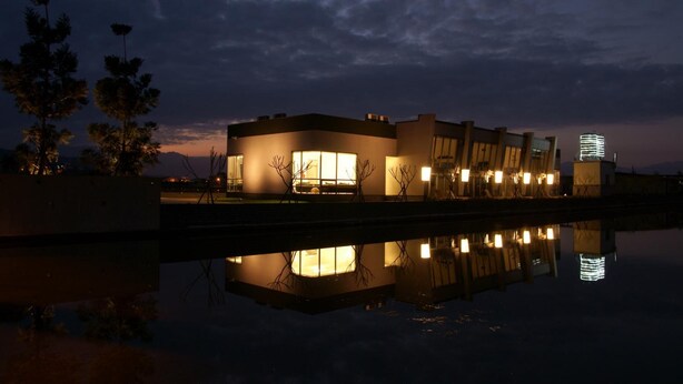 A modern building with a reflective pool at its base, large windows, and a flat roof. - Lan Yang Resort Four Seasons (Dongshan)