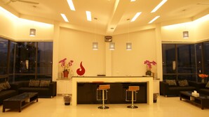 A modern hotel lobby with a reception desk, two sofas, a coffee table, and pendant lights. - Lan Yang Resort Four Seasons (Dongshan)