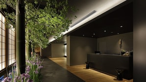 A modern reception area with a wooden floor, a reception desk, and a large window with a view of greenery. - Hotel Resol Kyoto Kawaramachi Sanjo (Kyoto)