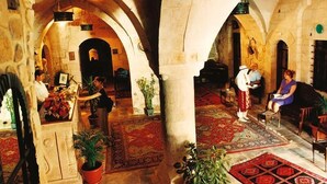 An interior with arches, a reception desk, and people. - Artuklu Kervansarayi - Special Class (Mardin)