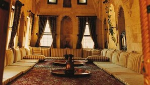 A traditional room with a patterned carpet, striped sofas, and a central coffee table. - Artuklu Kervansarayi - Special Class (Mardin)