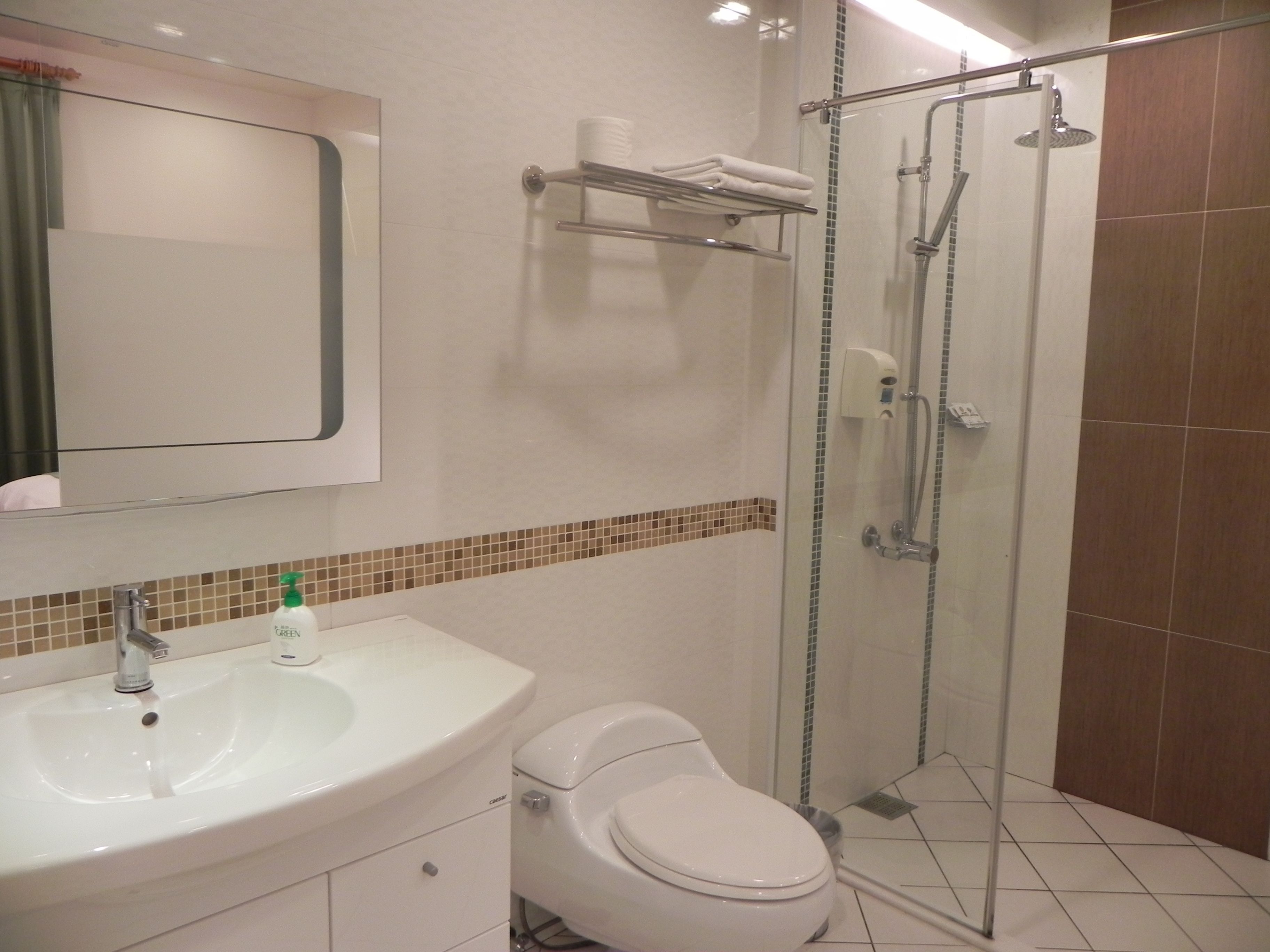 Un baño con lavamanos blanco, inodoro y cabina de ducha de vidrio.