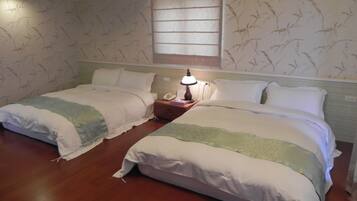 Two single beds with matching headboards, a bedside table with a lamp, and a patterned wallpaper.