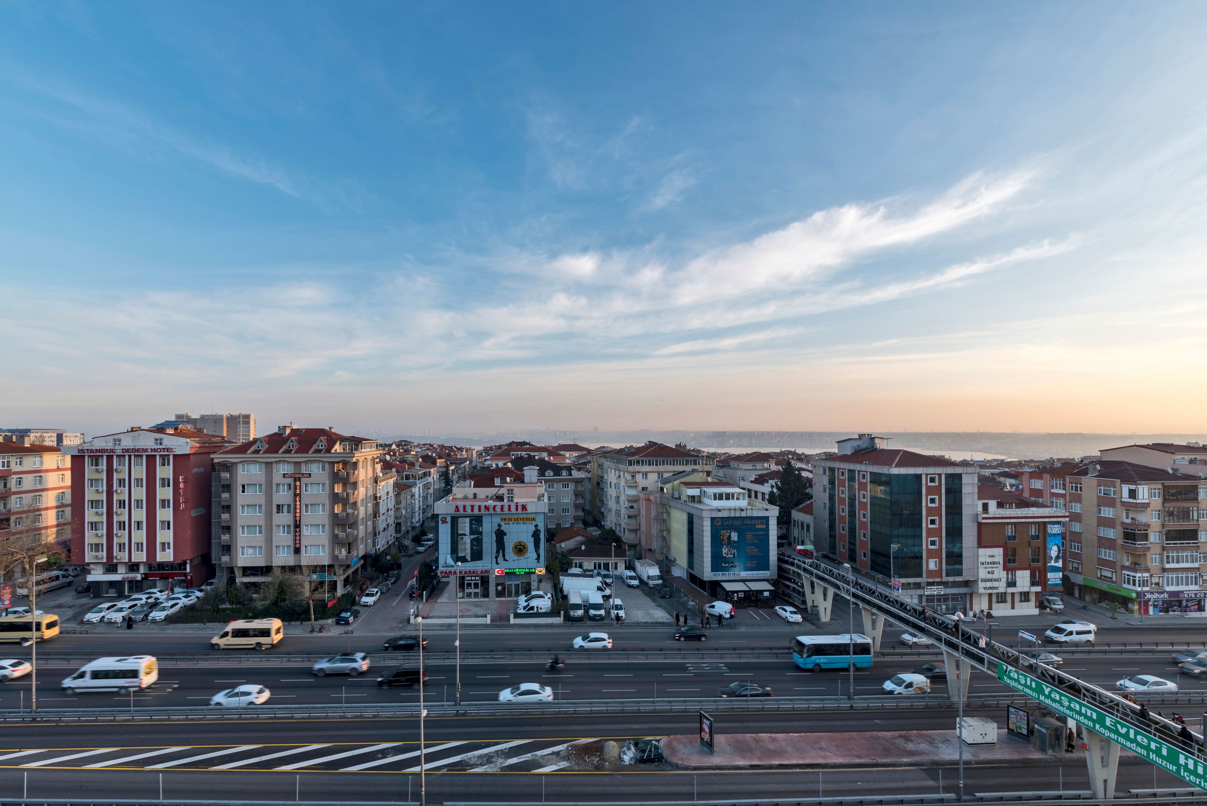 Un paisaje urbano con un edificio destacado que dice "ISTANBUL HOTEL", con una entrada amplia y varios pisos.
