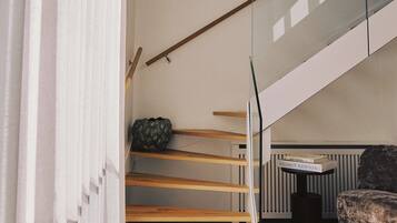 A modern interior with a staircase, a sofa, and a radiator.