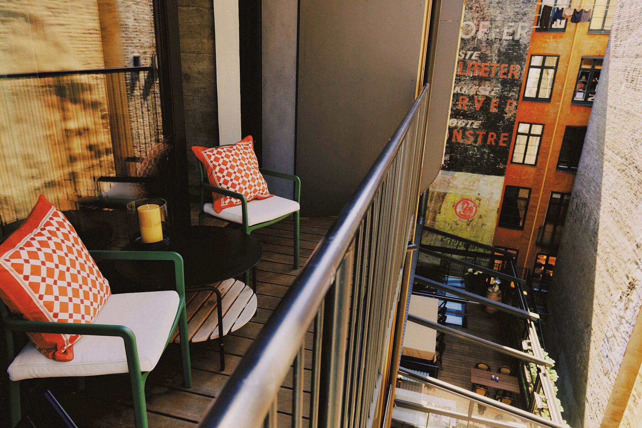 A balcony with two chairs, a small table, and a candle.
