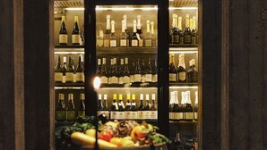 A bar area with shelves of wine bottles and a fruit display.