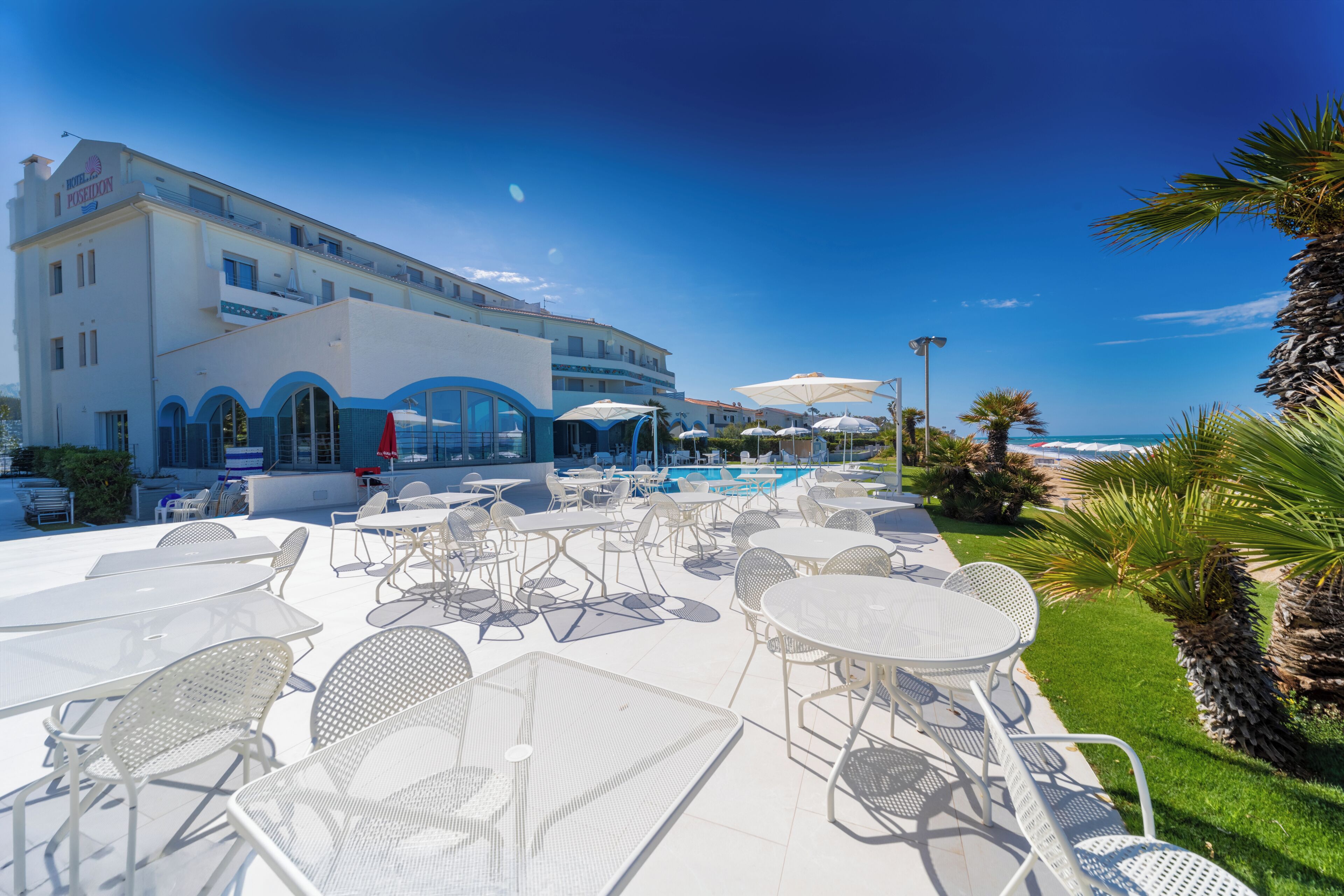 A hotel with outdoor seating and a pool.