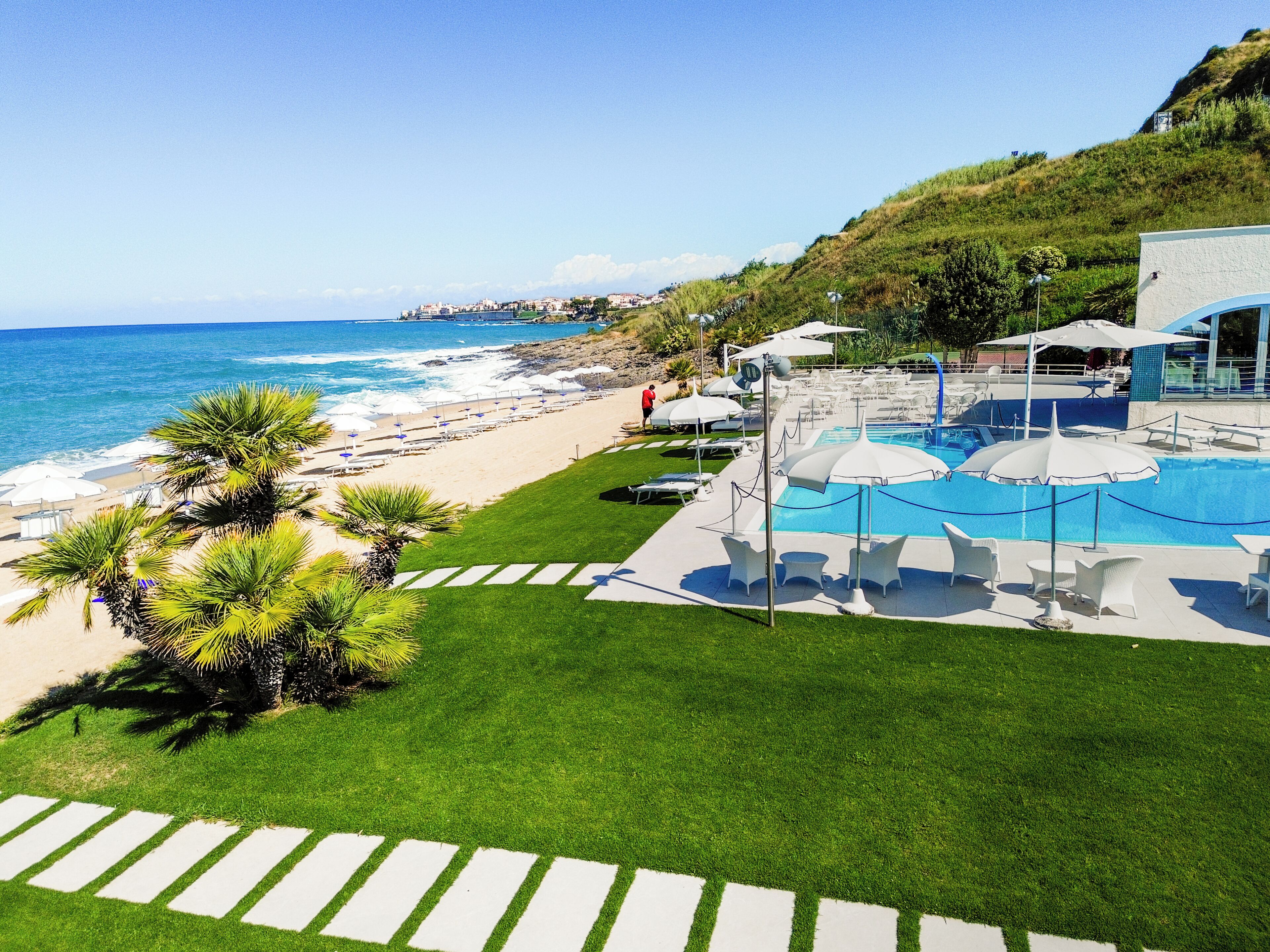 A resort with a pool, beach, and ocean view.