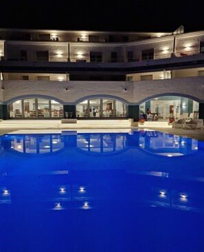 Una piscina al aire libre de temporada, sombrillas