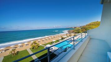 Ein Balkon mit Blick auf einen Strand, ein Schwimmbad und den Ozean.