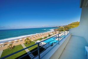 Un balcon avec vue sur une plage, une piscine et l’océan.