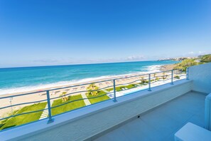 Un balcón con vista a la playa y al océano.