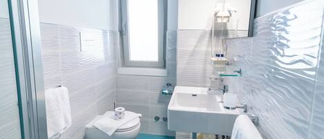 A modern bathroom with a bidet, a sink, and a mirror.