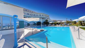 Una piscina al aire libre de temporada, sombrillas