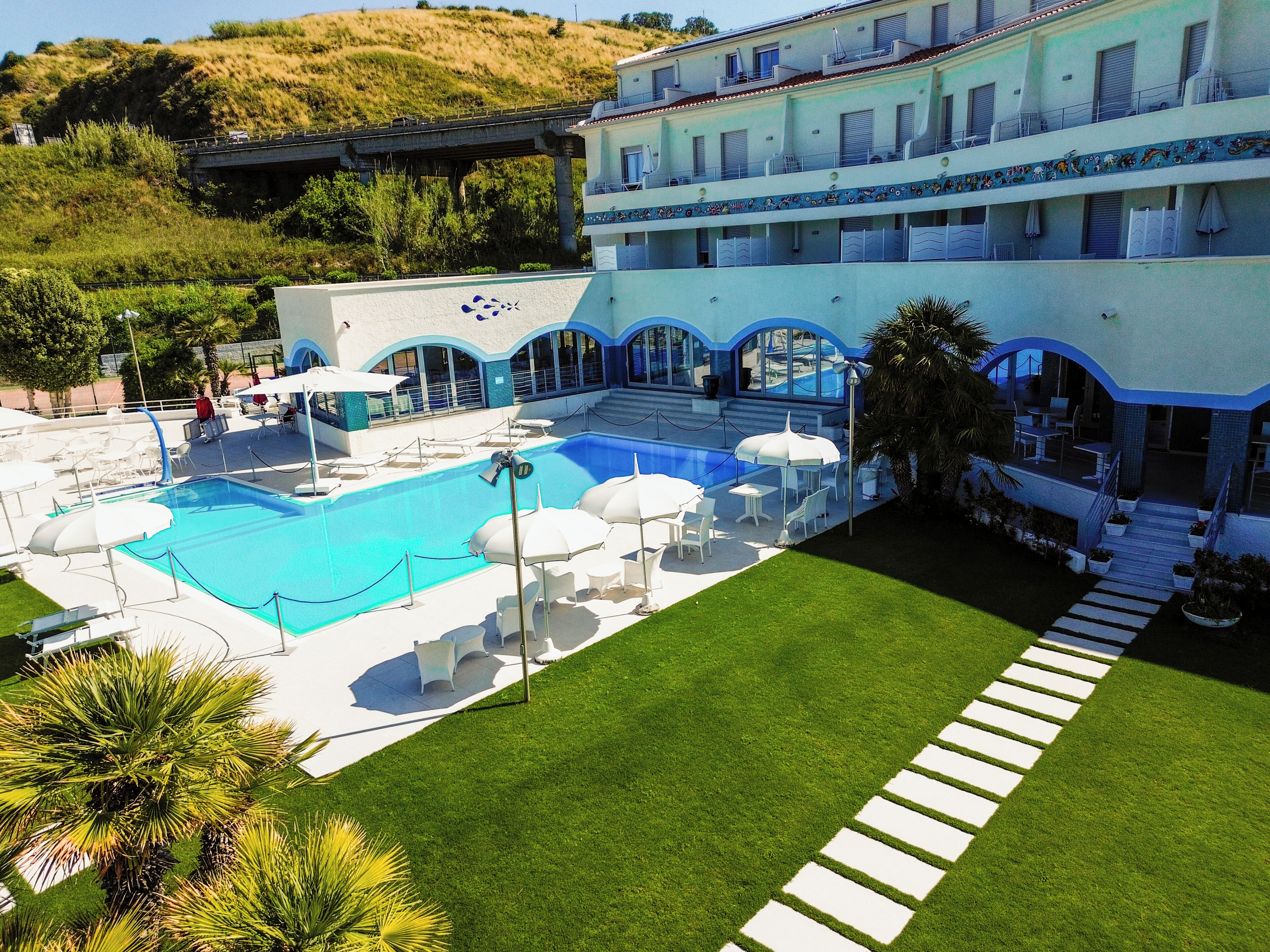 Un hôtel doté d’une piscine, d’un espace extérieur aménagé et d’un jardin paysager.
