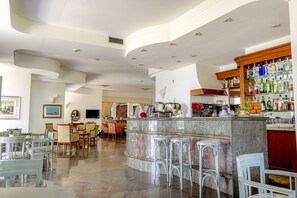 A spacious bar area with a marble countertop, bar stools, and a variety of liquor bottles. - Hotel Poseidon (Belvedere Marittimo)