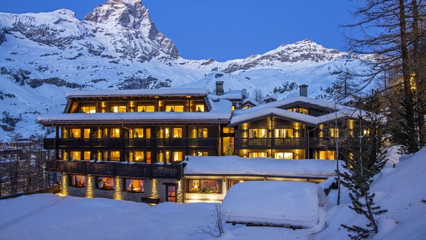 A multi-story hotel with balconies and a mountain backdrop. - Hermitage Hotel (Valtournenche)