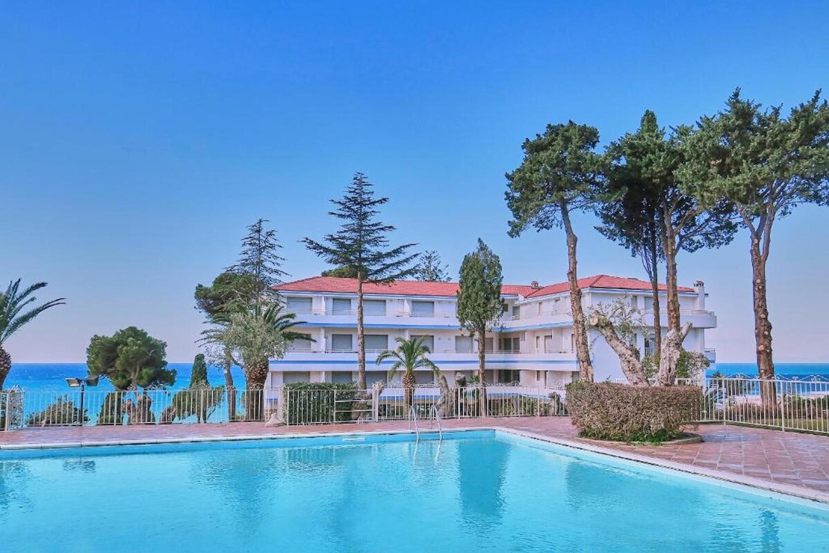 Une piscine avec vue sur un immeuble et la mer.