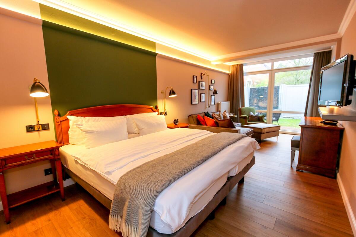 Une chambre d’hôtel avec un grand lit, des tables de chevet, une télévision et une vue sur l’extérieur.