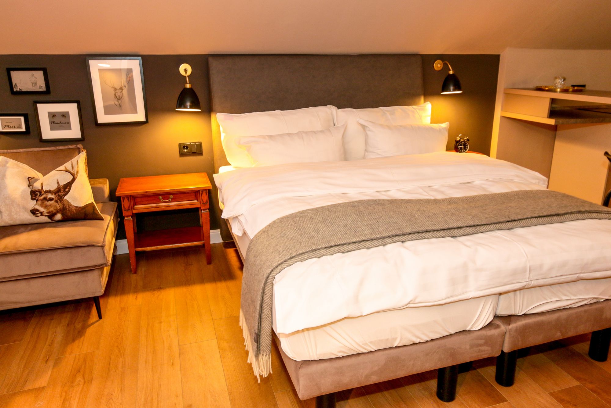 Een netjes opgemaakt slaapkamer met een bed, nachtkastjes en een bedtafeltje.
