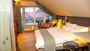 Quarto com uma cama grande, uma escrivaninha e vista para o exterior.