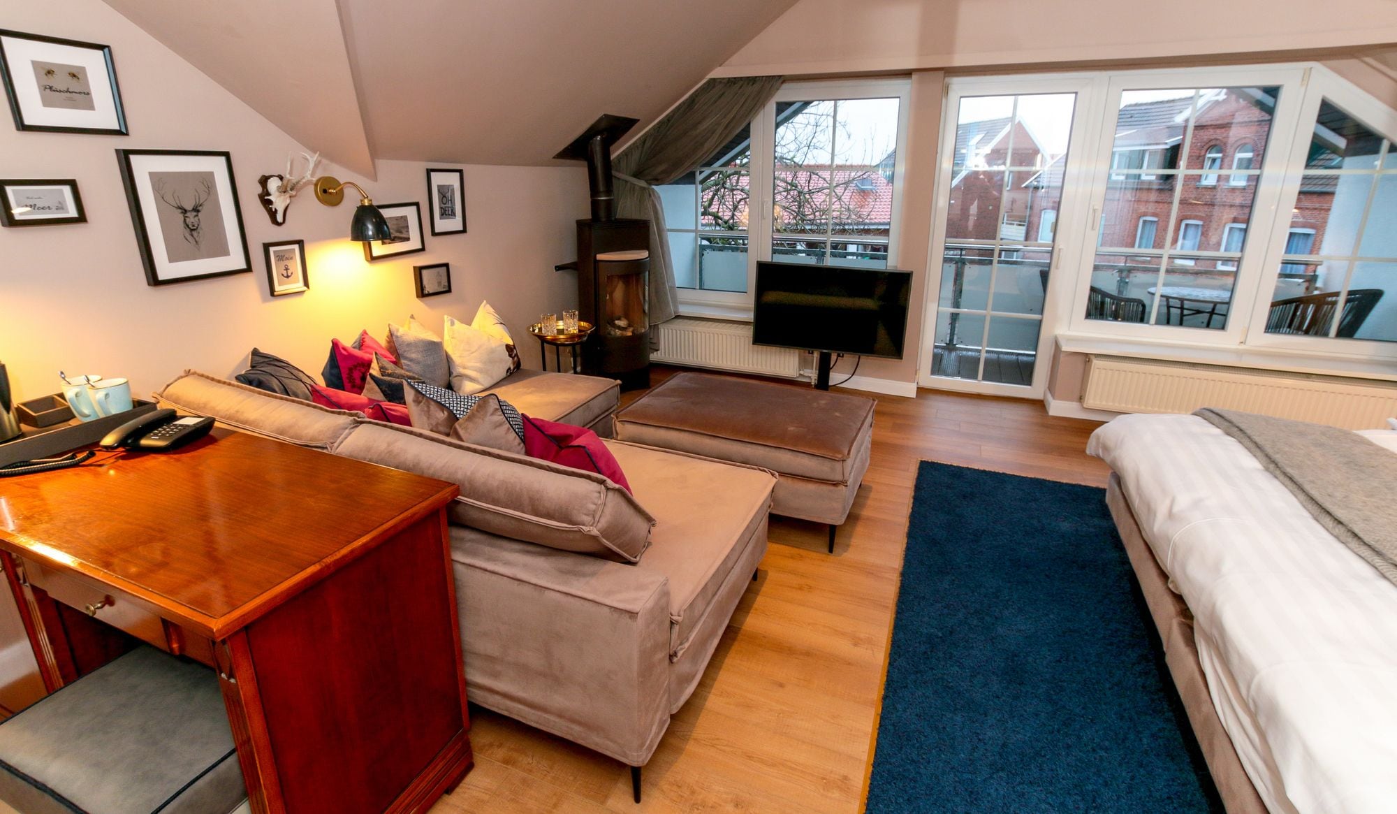 A cozy living room with a sofa set, a wooden table, a TV, and a fireplace.