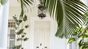 A grand entrance with a white door, steps leading up to it, and potted plants on either side. - La Reserva Vedado (Havana)