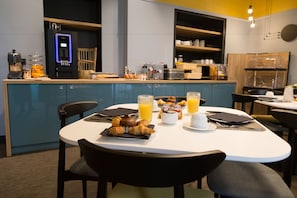 A breakfast setup with croissants, orange juice, and coffee.
