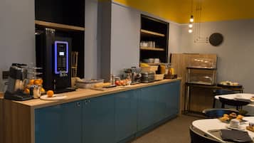 A modern kitchen with a coffee machine, fruit bowl, and breakfast items on the counter.