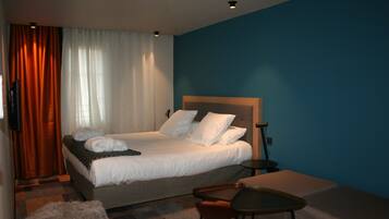 A hotel room with a bed, a desk, and a chair.