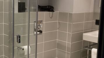 A modern bathroom with a glass shower enclosure, a white toilet, and a sink.