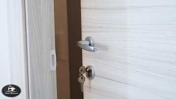 A door with a silver handle and a keyhole, and a white keychain hanging on the door.