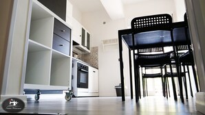 Una cocina moderna con armarios blancos, horno empotrado y un ventanal.