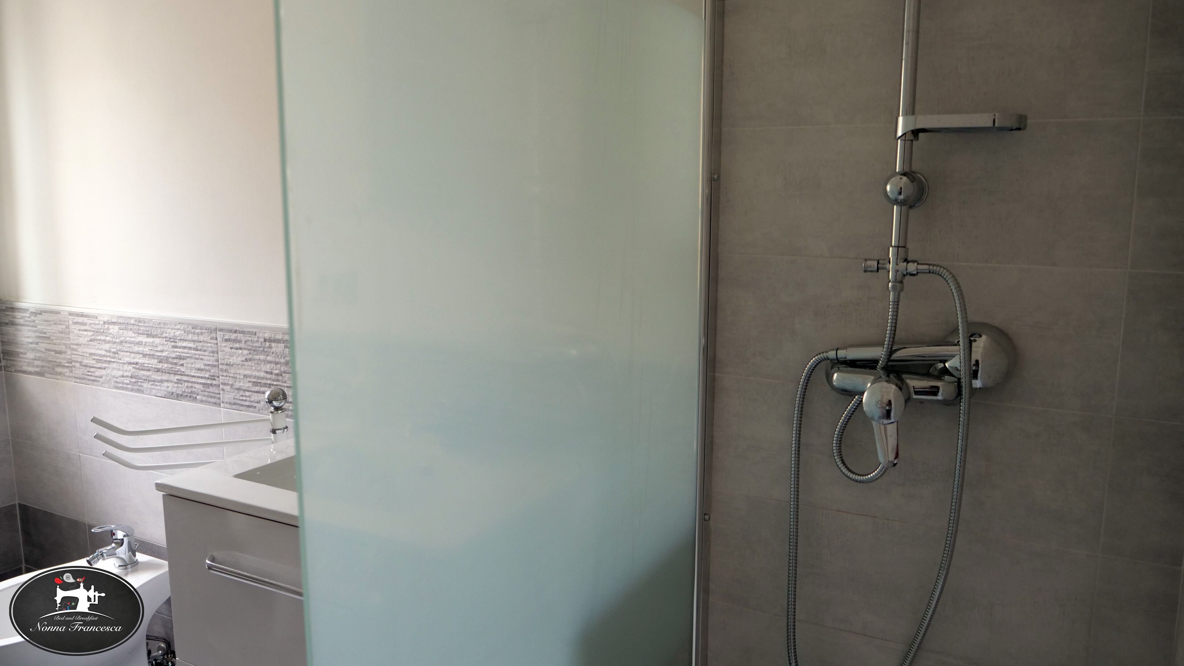 A modern bathroom with a glass shower enclosure, a built-in sink, and a towel rack.