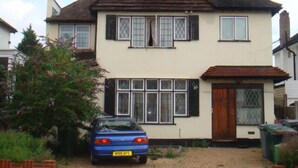 A two-story house with a pitched roof, a front door, and a driveway. - Draycott Guest House (Harrow)